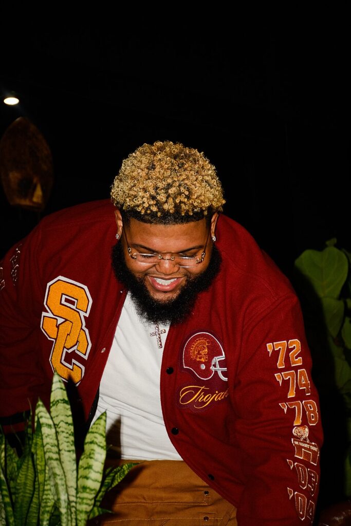 Druski, the comedian set to host SNL, laughing on stage at the Essence Festival of Culture in 2025