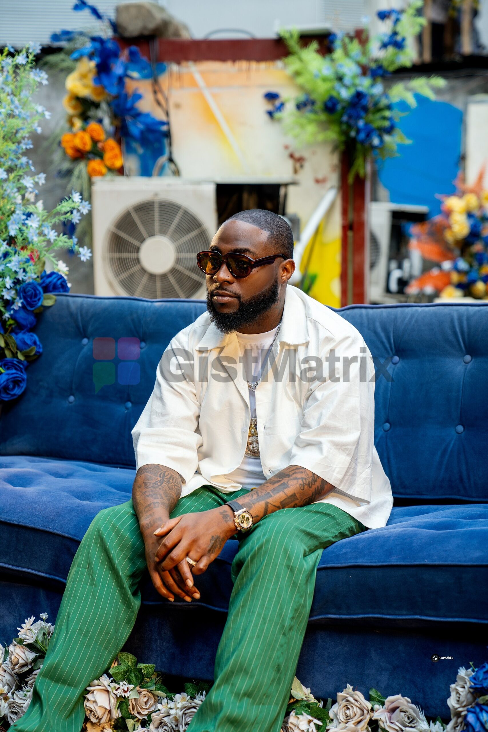 Davido seated on a blue sofa in 2024